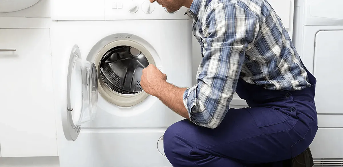 Handyman inspecting a dryer drum and internal parts for repair in Charlotte, NC