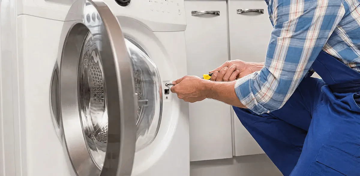 Handyman repairing a clothes dryer and checking electrical connections in Charlotte, NC