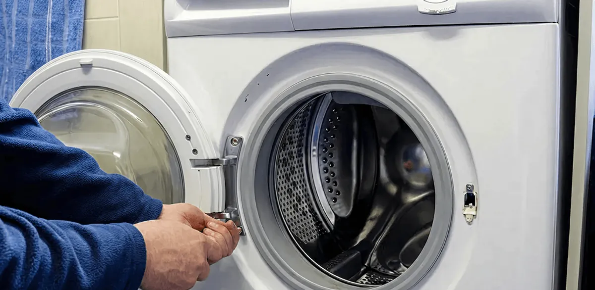 Washing machine repair handyman checking a front-load washer door and latch in Charlotte, NC