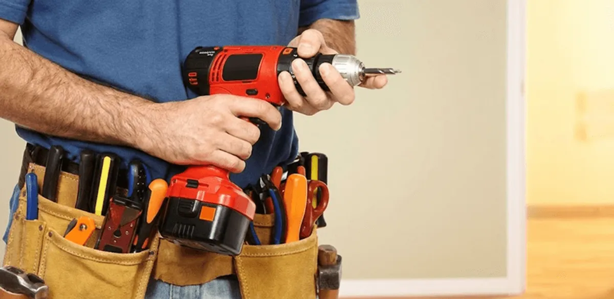 Handyman holding a power drill for home repairs and installations in Charlotte, NC