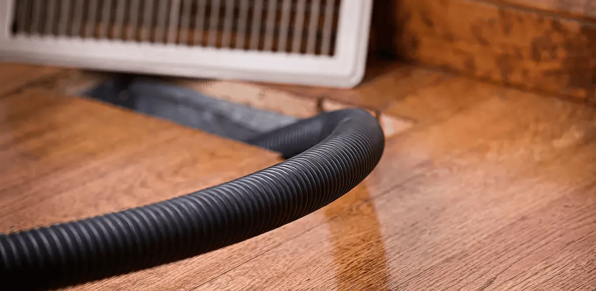 Air duct cleaning hose inserted into a floor vent for ductwork cleaning in Charlotte, NC