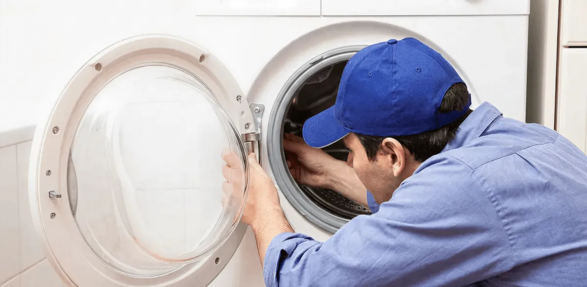 Washing machine repair handyman inspecting a front-load washer drum in Charlotte, NC